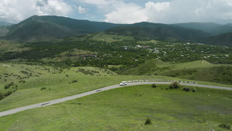 Car-Driving-Down-A-Long-And-Winding-Road-Passing-Through-Lush-Green-Hills-Outside-Aspindza-In-Georgia