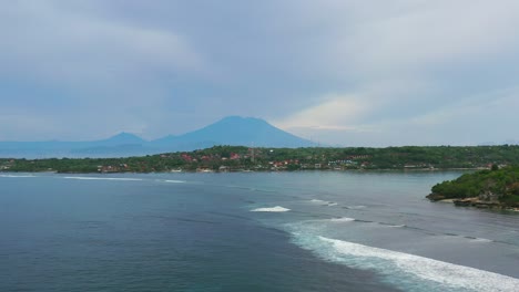 aerial-of-Nusa-Lembongan-Island-with-volcano-on-horizon-on-cloudy-day