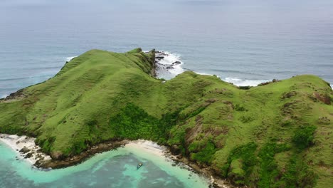 aerial-zoom-out-of-rocky-white-sand-beach-at-Bukit-Merese-Lombok-on-cloudy-day