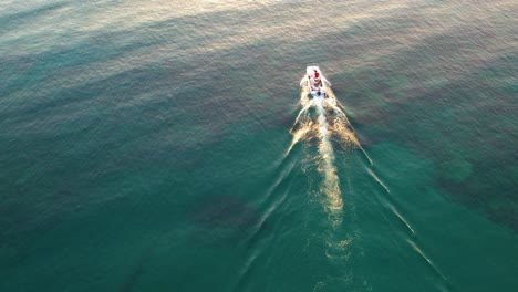 Aerial-of-a-boat-in-the-ocean-camera-goes-up-towards-sunrise-in-Cyprus