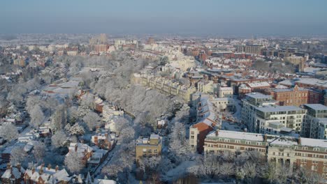 Cinematic-aerial-establishing-shot-of-Nottingham-England-featuring-snow-covered-houses-during-winter-months