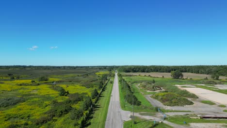 Drone-shot-flying-over-beautiful-countryside-rural-road-in-summer-sun