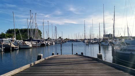 Evening-time-lapse-of-a-wooden-jetty-at-a-small-dutch-harbour-with-numerous-sail-boats