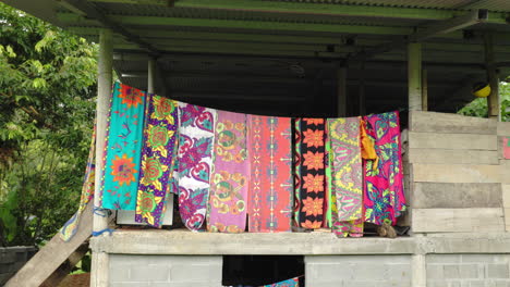 Cuts-of-very-colored-silk-fabric,-designed-by-a-tribe-in-Panama,-hanging-on-a-wooden-rural-house