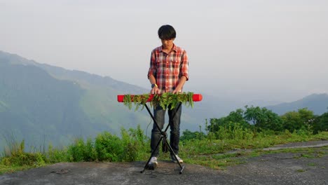 A-stationary-footage-of-a-man,-playing-his-electronic-musical-keyboard-with-a-mountain-view-in-the-background
