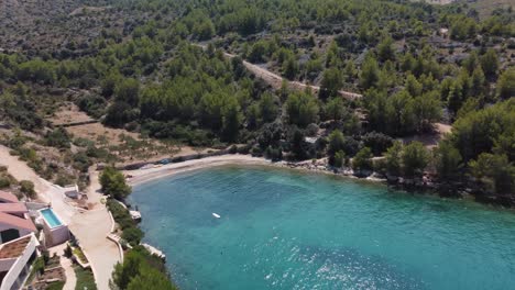 Fly-away-shot-of-secluded-private-beach-in-Brac,-Croatia-with-beautiful-turquoise-waters-of-Adriatic-Sea