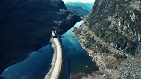 An-aerial-view-of-the-narrow-road-going-through-the-valley-and-leading-into-the-tunnel