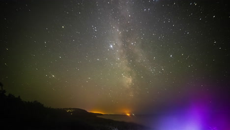Timelapse-shot-of-star-movement-along-starry-night-with-milky-way-passing-by-along-seaside
