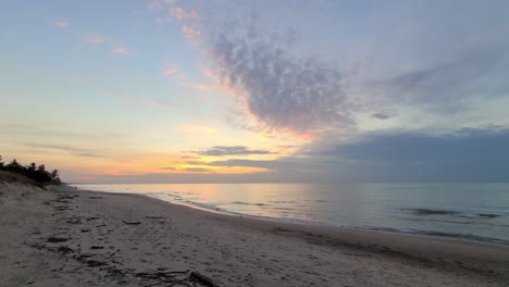 Schöne-Aussicht-Auf-Den-Sonnenuntergang-Hinter-Den-Wolken-An-Einem-Sandstrand,-Spazieren-An-Einem-Leeren-Strand