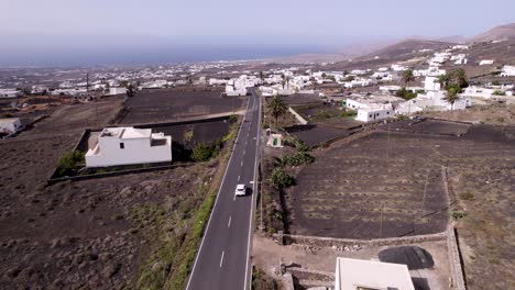 Aerial-shot-of-driving-car-and-desert-town