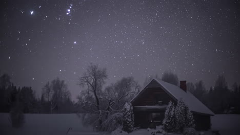 Cielo-Nocturno-Estrellado-Sobre-Paisaje-Invernal-Con-Cabaña-De-Madera-Solitaria-En-La-Nieve