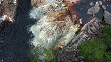 Luftdrohne-Von-Oben-Nach-Unten-Aufsteigende-Aufnahme-Des-Atemberaubenden-Teufelsgrubenwasserfalls,-Umgeben-Von-Felsen-Und-Dschungellaub-Im-Wunderschönen-Nationalpark-Chapada-Diamantina-Im-Nordosten-Brasiliens