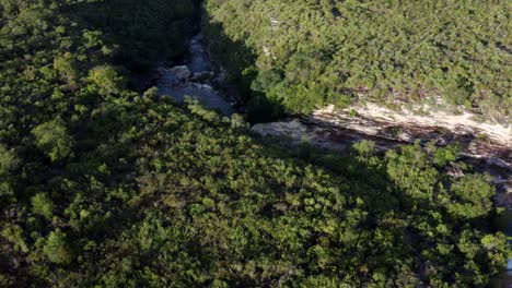 Beautiful-bird's-eye-view-aerial-drone-shot-looking-down-and-flying-towards-the-Devil's-Pit-Waterfall-in-the-stunning-Chapada-Diamantina-National-Park-in-Northeastern-Brazil