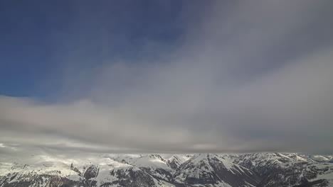 Zeitraffer-Der-Wolkenlandschaft-über-Schneebedeckten-Gipfeln-Der-Malerischen-Bergkette---Geschwollene-Weiße-Wolken,-Die-Durch-Den-Blauen-Himmel-Fliegen