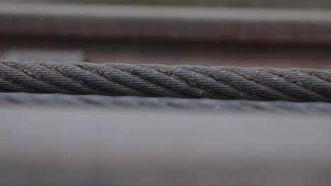 handheld-close-up-shot-of-industrial-braided-iron-cable-getting-retracted