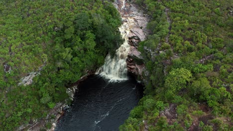 Drone-Aéreo-Inclinándose-Hacia-Abajo-De-La-Impresionante-Cascada-Del-Pozo-Del-Diablo-Rodeada-De-Rocas-Y-Follaje-De-La-Jungla-En-El-Hermoso-Parque-Nacional-Chapada-Diamantina-En-El-Noreste-De-Brasil-En-Un-Día-Nublado