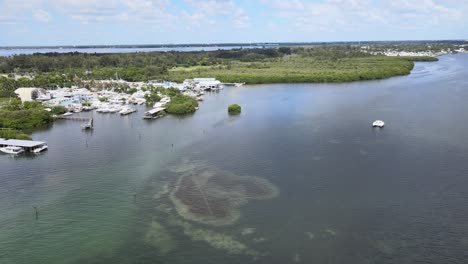 Aerial-looking-south-to-Sarasota-Bay-then-turning-north-to-view-fishing-boats-and-the-Cortez-section-of-Bradenton,-Florida