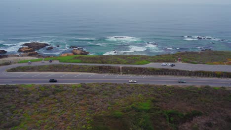 Slide-Follow-Aerial-Drone-Shot-Of-Cars-Driving-in-Fog-On-Pacific-Coast-Highway-crossing-bridge-by-San-Gregorio-Beach-in-California,-USA
