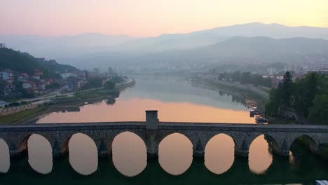 Aerial-of-bridge-over-drina-river-sunrise-in-Visegrad,-bosnia-herzegovina