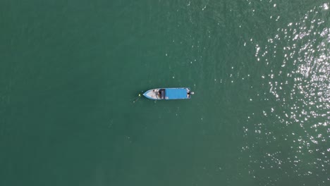 Static-Top-Down-Shot-Of-A-Fishermans-Boat-Anchored-In-The-Ocean