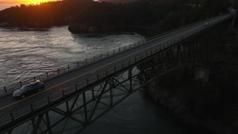 Aerial-shot-of-Deception-Pass-at-dusk-with-golden-hour-glow-peaking-through-the-horizon