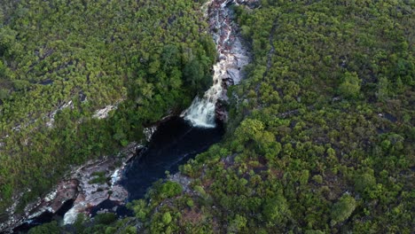 Rotierende-Luftdrohnenaufnahme-Des-Atemberaubenden-Wasserfalls-Devil&#39;s-Pit,-Umgeben-Von-Felsen-Und-Dschungellaub-Im-Wunderschönen-Nationalpark-Chapada-Diamantina-Im-Nordosten-Brasiliens-An-Einem-Bewölkten-Tag
