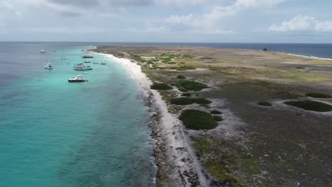 Drohne-Fliegt-über-Felsige-Korallenküste-An-Der-Küste-Mit-Klarer-Meerwasser-Privatinsel-Mit-Verankerten-Booten