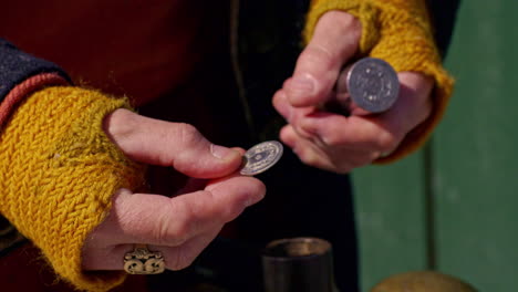 Examining-a-freshly-minted-coin-made-from-a-vintage-Viking-coin-punch---isolated