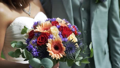 Wedding-couple-holding-a-bouquet-of-flowers