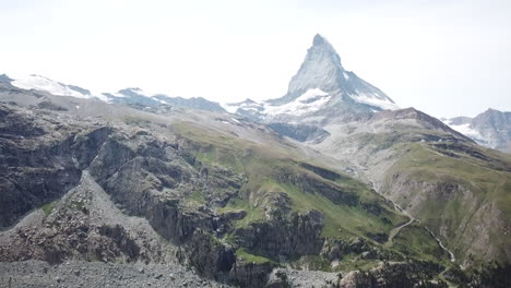 Inclinación-Hacia-Arriba:-Vista-Aérea-De-Drones-En-El-Cervin,-Zermatt-Con-Un-Cielo-Azul,-Paisaje-De-Recursos-De-Los-Alpes-Suizos,-Cumbre-Rocosa