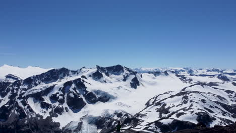 Epische-Luftdrohnenaufnahme-Eines-Wanderers,-Der-über-Eine-Riesige-Schneebedeckte-Berglandschaft-In-Den-Pazifischen-Gebirgszügen-Kanadas-Bc-4k-Blickt