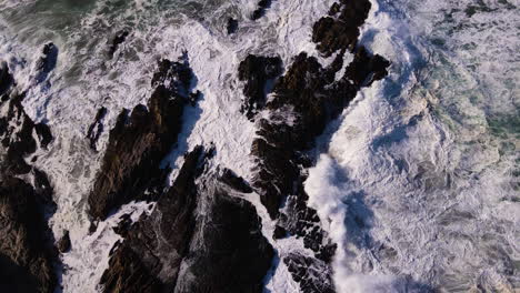 Foaming-seawater-as-turbulent-ocean-crash-against-rocks