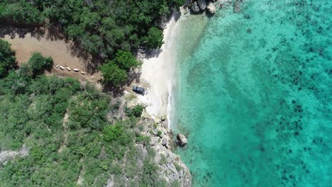 car-standing-still-near-coastline-clear-water-drone-view-and-trees-private-beach