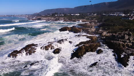 Aerial-arc---frothing-seawater-as-incessant-waves-pound-rocky-coastline