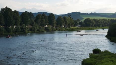 Calm,-Idyllic,-Relaxing-Scene-Of-Shallow-River-In-Slovakia-With-Boats-Cruising-On-It---Mountain-Environment