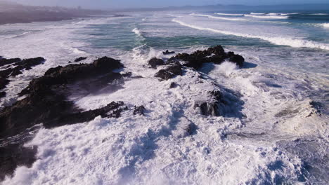 Wave-spray-thrown-high-as-waves-crash-dramatically-against-rocky-coastline