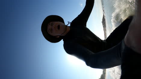 Vertikale-Aufnahme-Eines-Männlichen-Surfers,-Der-Selfie-Mit-Handheld-action-kamera-Macht,-Während-Er-Im-Sommer-Im-Meer-Surft
