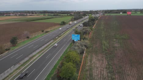 Aerial-Lifting-Drone-View-Showing-Of-Busy-Hungarian-Highway,-Beautiful-Lake-In-The-Background