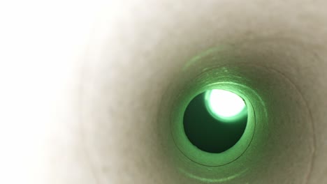 Backing-out-from-inside-a-paper-towel-tube-with-a-green-light-at-the-end