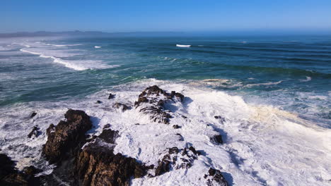 Waves-smashing-against-jagged-rocks-on-shoreline---tumultuous-ocean
