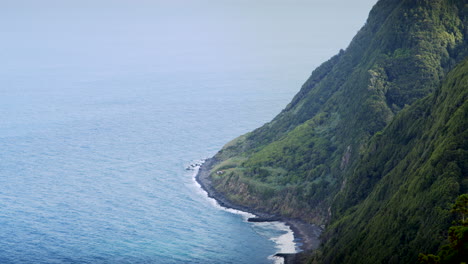 Dark-Sand-Beach-at-Steep-Cliffs-of-Azores-in-Beautiful-Green-Nature