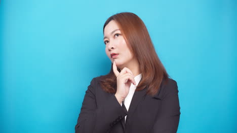 Uncertain-young-businesswoman-thinking-and-looking-up-having-idea-enlightenment-standing-isolated-over-a-blue-background