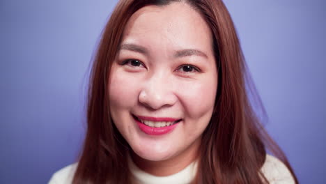 Nahaufnahme-Porträt-Einer-Attraktiven-Asiatischen-Frau,-Die-Glücklich-Lächelnd-Und-Selbstbewusst-Fröhlich-Mit-Violettem-Hintergrund-Mit-Weichem-Fokus-Ist