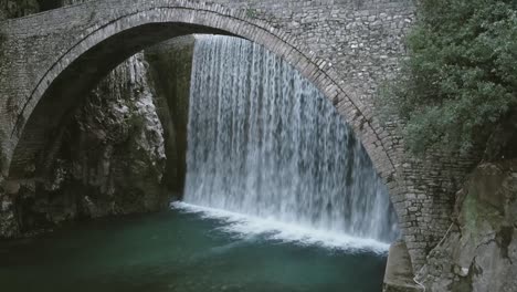 Cascada-Y-Un-Viejo-Puente-Empedrado-En-Un-Pequeño-Pueblo-En-Grecia
