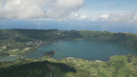 Beautiful-drone-footage-of-the-volcanic-mountain-lakes-of-the-Azores-islands-and-surrounding-lush-green-forests,-fields-and-cliffs-and-the-Atlantic-ocean