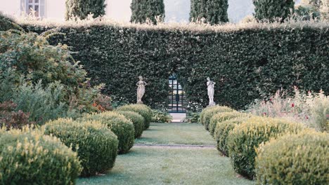 Spazieren-Durch-Den-Garten-Mit-Viel-Grün-Und-Statuen-Der-Berühmten-Historischen-Mediterranen-Villa-Balbiano-Am-Comer-See-Italien-Hochzeitsort---Filmische-Zeitlupe