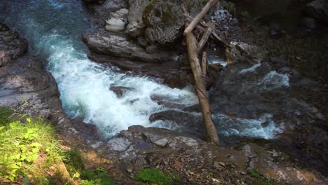 Ein-Blauer,-Kalter-Und-Klarer-Gebirgsfluss-Fließt-Durch-Eine-Schlucht-In-Den-Alpen,-Wasser-Schäumt-Auf