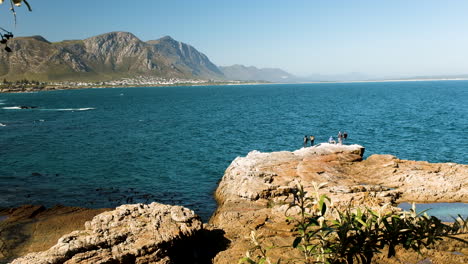 Tourists-observing-whales-that's-close-to-rocky-shore---Hermanus-whale-watching