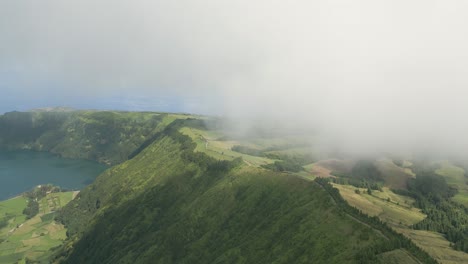 Beautiful-drone-footage-of-the-volcanic-mountain-lakes-of-the-Azores-islands-and-surrounding-lush-green-forests,-fields-and-cliffs-and-the-Atlantic-ocean