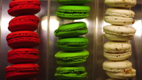 Scrolling-closeup-view-of-vibrant-red,-green,-and-cream-French-macaron-pastries